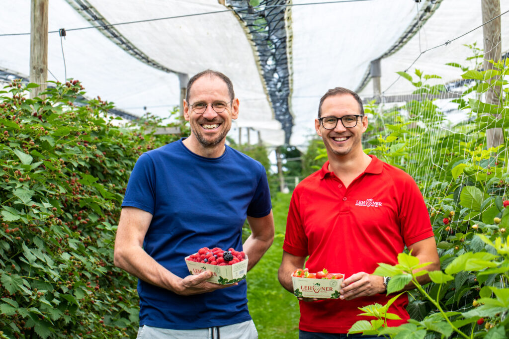 Gerhard Winkler und Erdbeerbauer Lehner halten Beeren in den Händen